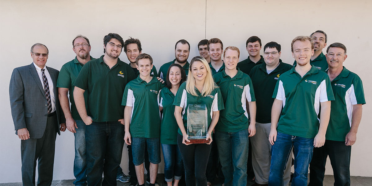 Debate Team standing with trophy